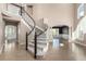 Elegant curved staircase with gray carpeting and dark wood railing at 7203 S Ukraine St, Aurora, CO 80016