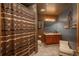 Bathroom with tiled shower, wooden vanity, and a small bench at 3891 Windchant Cir, Castle Rock, CO 80104