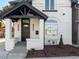 Charming front porch with a modern dark brown door and a white exterior at 512 W 8Th Ave, Denver, CO 80204