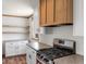 Kitchen features a range, shaker cabinets, and wood accents at 15 S County Road 197, Byers, CO 80103
