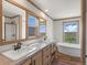 Bathroom with double vanity, soaking tub, and window view at 15 S County Road 197, Byers, CO 80103