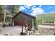 Green cabin with a wooden deck and mountain views at 573 97 Cir, Breckenridge, CO 80424