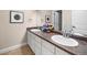 Double vanity bathroom with dark countertop and white cabinets at 10215 W Wesley Dr, Lakewood, CO 80227