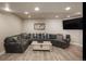 Spacious basement living area with sectional sofa and large TV at 10215 W Wesley Dr, Lakewood, CO 80227