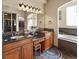 Elegant bathroom with double sinks, granite countertops, and a soaking tub at 10215 W Wesley Dr, Lakewood, CO 80227