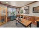 Home office with wood-paneled walls, a large desk, and built-in shelving at 10215 W Wesley Dr, Lakewood, CO 80227
