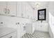 Bright laundry room with white cabinets and patterned flooring at 457 S Vine St, Denver, CO 80209
