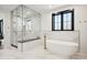 Luxurious bathroom with soaking tub, glass shower, and marble tile at 457 S Vine St, Denver, CO 80209