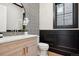 Stylish powder room with patterned wallpaper, modern vanity, and mosaic tile accents at 457 S Vine St, Denver, CO 80209