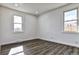 Well-lit bedroom featuring wood-look floors and two windows at 15360 W 44Th Ave, Golden, CO 80403