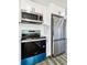 Modern kitchen featuring stainless steel appliances and blue stove at 15360 W 44Th Ave, Golden, CO 80403