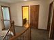 Upstairs hallway with carpet, wood railing, and access to bathroom and bedrooms at 21064 E Crestline Cir, Centennial, CO 80015