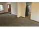 Open living space with carpet and kitchen access at 21064 E Crestline Cir, Centennial, CO 80015