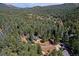 Bird's-eye view of a home on a wooded lot in the mountains at 5673 Santa Clara Rd, Indian Hills, CO 80454