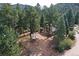 House surrounded by trees, driveway, and distant mountain views at 5673 Santa Clara Rd, Indian Hills, CO 80454