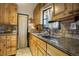 Bright kitchen featuring wood cabinets and granite countertops at 5673 Santa Clara Rd, Indian Hills, CO 80454