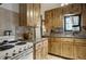 Cabin kitchen with wood cabinets, granite counters and a stove at 5673 Santa Clara Rd, Indian Hills, CO 80454