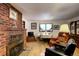 Cozy living room features a brick fireplace and comfortable seating at 5673 Santa Clara Rd, Indian Hills, CO 80454