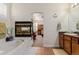 Bathroom with a bathtub, fireplace, and a view into the bedroom at 12955 Vallejo Cir, Westminster, CO 80234
