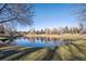 Serene pond with reflection of trees and houses, creating a tranquil atmosphere at 6269 S Coventry E Ln, Littleton, CO 80123