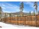 Wooden fence with snowy yard and mountain backdrop at 9660 City View Dr, Morrison, CO 80465