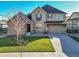 Two-story house with stone accents, a large driveway, and a landscaped lawn at 14672 Melco Ave, Parker, CO 80134