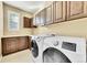 Laundry room with washer, dryer, and custom cabinetry at 14672 Melco Ave, Parker, CO 80134