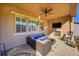 Covered patio with seating area, fireplace, and ceiling fan at 14672 Melco Ave, Parker, CO 80134