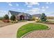 Brick and gray-sided two story house with landscaped yard and curved driveway at 29850 E 167Th Pl, Brighton, CO 80603