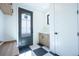 Bright entryway with built-in bench, wood cabinets, and black and white floor at 2200 Newton St, Denver, CO 80211