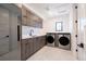 Modern laundry room with washer, dryer, and custom cabinetry at 2200 Newton St, Denver, CO 80211