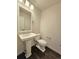 Clean bathroom with pedestal sink and dark hardwood floors at 6435 E Cedar Ave, Denver, CO 80224