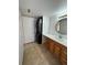 Bright bathroom with a stacked washer and dryer, vanity, and tiled floor at 9725 E Harvard Ave # 322, Denver, CO 80231