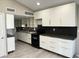 Modern kitchen with white cabinets and hexagon tile backsplash at 3414 S Locust St # D, Denver, CO 80222