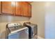 Convenient laundry room with washer, dryer, and upper cabinets at 8537 E 35Th Ave, Denver, CO 80238