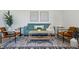 Living area features teal sofa, light wood coffee table, and two armchairs at 1601 Park Ave # 216, Denver, CO 80218
