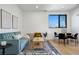 Open concept living area with teal sofa, light wood coffee table, and dining area at 1601 Park Ave # 216, Denver, CO 80218