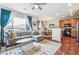 Open living room with hardwood floors, L-shaped sofa, and adjacent kitchen at 13042 Grant E Cir # C, Thornton, CO 80241