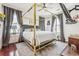 Main bedroom with a gold canopy bed, hardwood floors and plenty of natural light at 13042 Grant E Cir # C, Thornton, CO 80241