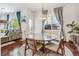 Bright dining room with a round glass table and four chairs, hardwood floors and large windows at 13042 Grant E Cir # C, Thornton, CO 80241