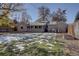 Spacious backyard with partial snow cover, showing home's back elevation at 2812 Krameria St, Denver, CO 80207