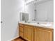 Bathroom features a vanity with wood cabinets and a large mirror at 5726 N Genoa Way # 10-106, Aurora, CO 80019