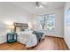 Cozy bedroom with large window, wood floors, and a ceiling fan at 5726 N Genoa Way # 10-106, Aurora, CO 80019