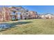Exterior view of the building with green space at 5726 N Genoa Way # 10-106, Aurora, CO 80019