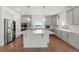 Modern kitchen with white cabinets and large island at 5049 Liverpool St, Denver, CO 80249