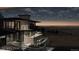 Night view of home's exterior showcasing deck and city views at 63 Canyon Pines Dr, Arvada, CO 80403