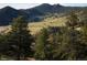 Aerial view of a residential area with mountain views and lush green landscape at 63 Canyon Pines Dr, Arvada, CO 80403