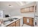 Kitchen with wood cabinets, double sink, and view of living room at 11103 E Alameda Ave # 102, Aurora, CO 80012