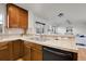 Kitchen with wood cabinets, tile countertops, and stainless steel dishwasher at 10108 E 31St Ave, Denver, CO 80238