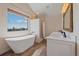 Spa-like bathroom with soaking tub, double vanity, and mountain views at 6929 Weasel Way, Evergreen, CO 80439